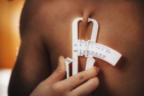 Врач, измеряющий жир на подлопатке с помощью суппортов, проверяет на спортсмене мужского пола
. — стоковое фото