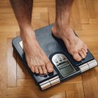Feet of male athlete measuring body composition with floor scale. — Stock Photo