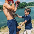 Grand-père et petit-fils boxe au bord du lac en plein air . — Photo de stock