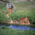 Agua contaminada químicamente que drena en el río Tame fuera de la tierra con desechos que contienen metales pesados, West Midlands, Reino Unido . - foto de stock