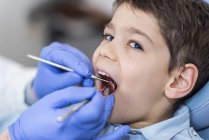 Menino da idade elementar fazendo check-up dentário . — Fotografia de Stock