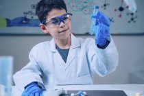 Écolier faisant des expériences de chimie dans un laboratoire scolaire . — Photo de stock