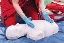 Hands of female paramedic CPR training outdoors. — Stock Photo
