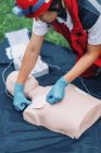 Female paramedic using defibrillator while training outdoors. — Stock Photo