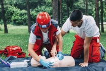 Жінка з парамедичним інструктором CPR тренування на маляті на відкритому повітрі . — стокове фото
