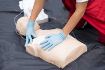Manos del entrenamiento de RCP paramédico femenino al aire libre . - foto de stock