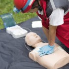 Female paramedic CPR training on dummy outdoors. — Stock Photo