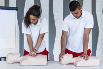 CPR class with instructors demonstrating first aid, compression and reanimation procedure. — Stock Photo