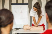 CPR-клас з інструктором, що демонструє процедуру надання першої допомоги, стиснення та реанімації . — стокове фото