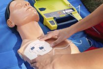 Rettungssanitäterin mit Defibrillator beim Training an CPR-Attrappe. — Stockfoto