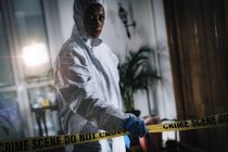 Esperto forense che incrocia il nastro adesivo sulla scena del crimine . — Foto stock