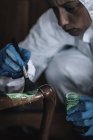 Forensics expert dusting for fingerprints at crime scene. — Stock Photo