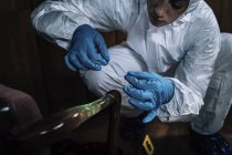 Forensics expert getting fingerprints with tape at crime scene. — Stock Photo