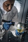 Forensik-Experte untersucht mit Taschenlampe Glas Wein am Tatort. — Stockfoto