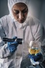 Forensik-Experte untersucht mit Taschenlampe Glas Wein am Tatort. — Stockfoto