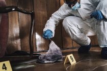 Forensics expert collecting evidence cloth from crime scene. — Stock Photo