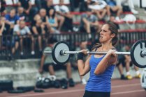 Young female athlete taking part in weightlifting competition. — Stock Photo