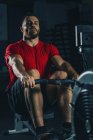 Man performing rowing machine workout in gym. — Stock Photo