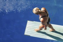 Vista de alto ângulo do mergulhador feminino andando no trampolim . — Fotografia de Stock