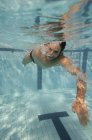 Человек плавает под водой после спортивного прыжка в бассейн . — стоковое фото