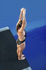 Vista de alto ângulo do mergulhador feminino com os braços para cima na plataforma
. — Fotografia de Stock