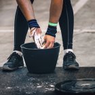 Low section of male weightlifter getting ready for training with chalk powder in bucket. — Stock Photo