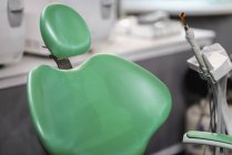 Крупним планом порожнє зелене стоматологічне крісло в медичній клініці . — стокове фото