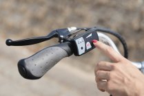 Mão feminina girando na bicicleta elétrica, close-up . — Fotografia de Stock