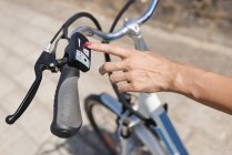 Жіноча рука вмикає електричний велосипед крупним планом . — стокове фото