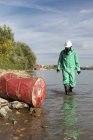 Pollution control inspector approaching barrel with hazardous waste. — Stock Photo