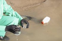 Trabalhador do ambiente que recolhe amostras de águas poluídas no local da poluição . — Fotografia de Stock