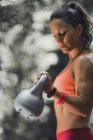 Female athlete exercising with kettlebell outdoors. — Stock Photo