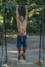 Ajuste hombre mayor ejercicio en la barra horizontal en el parque . - foto de stock