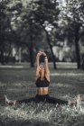 Athletic woman stretching legs and arms after exercise in park. — Stock Photo
