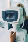 Paciente do sexo feminino submetida a exame oftalmológico com refratômetro automático . — Fotografia de Stock