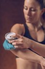 Sportswoman holding blue ice pack on painful elbow. — Stock Photo