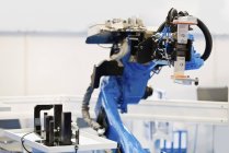 Brazo robótico industrial azul en fábrica de alta tecnología . - foto de stock