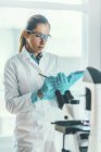 Biotechnology scientist taking note while biochemical research. — Stock Photo