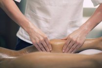 Фізіотерапевт масаж чоловічого телят застосування сильного тиску пальця. — стокове фото
