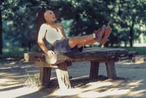 Ajuste hombre mayor haciendo ejercicio sobre equipos de madera en el parque
. - foto de stock