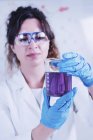 Молодая женщина-ученый проводит эксперимент с жидкостью в лаборатории . — стоковое фото