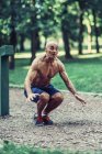 Fit senior man exercising in summer park. — Stock Photo