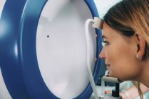 Frau unterzieht sich augenärztlichen Gesichtsfeldtests mit a-scan Ultraschall-Biometrie. — Stockfoto