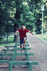 Fit senior man performing obstacle race in park. — Stock Photo