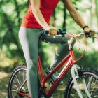 Cropped view of woman riding bike in park. — Stock Photo