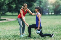 Women exercising with kettlebell in park outdoors. — Stock Photo