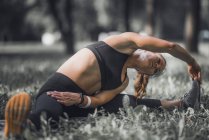 Female athlete stretching after exercise in park. — Stock Photo