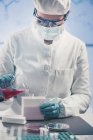 Microbiologista feminina trabalhando em laboratório com líquido de biotecnologia
. — Fotografia de Stock