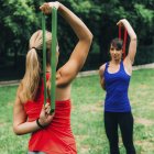 Donne che si allenano con elastici nel parco verde
. — Foto stock