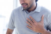 Homem adulto médio tocando no peito com dor . — Fotografia de Stock